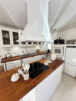 a kitchen with a wooden counter top and white appliances at Vilamoura Modern House in Quarteira