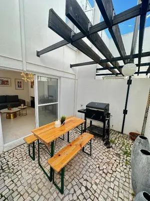 a patio with a wooden table and a piano at Vilamoura Modern House in Quarteira