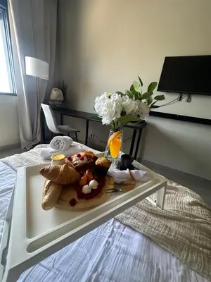 a tray with a plate of food on a bed at Beach Holidays in Quarteira