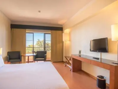 a hotel room with a bed and a flat screen tv at Hotel Vila Galé Cerro Alagoa in Albufeira