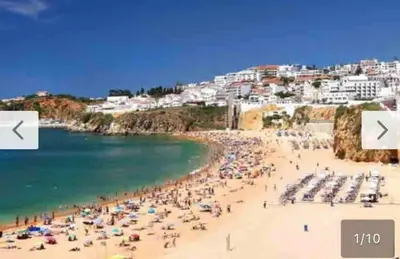a group of people on a beach with the ocean at House e Beach in Albufeira