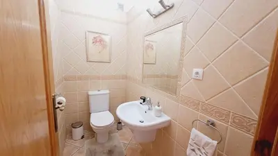 a bathroom with a white toilet and a sink at Albufeira Home Paderne in Paderne