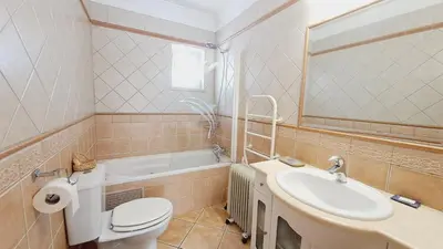 a bathroom with a toilet and a sink and a tub at Albufeira Home Paderne in Paderne