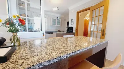 a kitchen with a counter with a vase of flowers at Albufeira Home Paderne in Paderne
