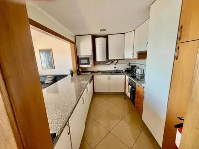 a kitchen with white cabinets and granite counter tops at Hofnar Sea View Apartment in Albufeira