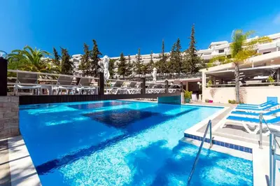 a swimming pool with blue water in front of a building at Apartamento Laurus in Albufeira