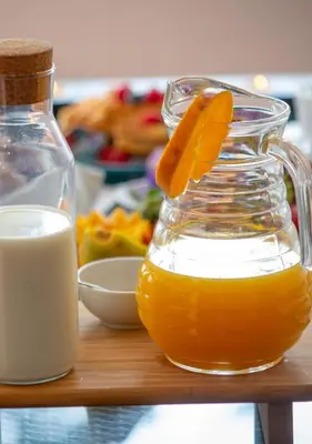 a jug of orange juice and a glass jar of milk at Apartamento Laurus in Albufeira