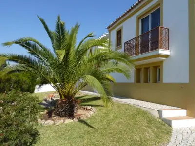 a palm tree in front of a house at Villa Ana in Albufeira
