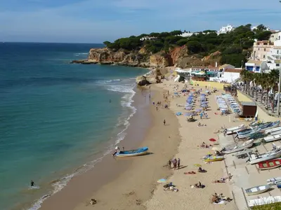 a beach with a lot of people and boats on it at Villa Ana in Albufeira
