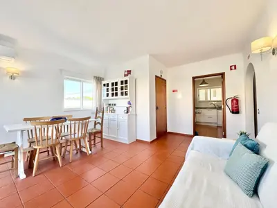 a living room with a table and a kitchen at Beach 15 min away! - Rustic with AC and WiFi in Quarteira