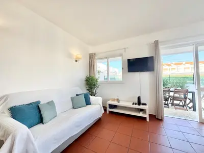 a living room with a white couch and a television at Beach 15 min away! - Rustic with AC and WiFi in Quarteira
