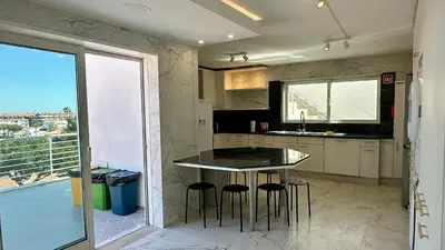 a kitchen with a table and chairs and a balcony at Ocean Drive by Check-in Portugal in Albufeira