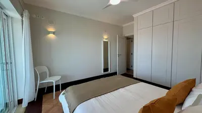a bedroom with a white bed and a chair at Ocean Drive by Check-in Portugal in Albufeira