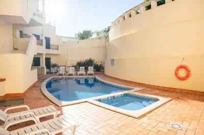 a swimming pool in a courtyard next to a building at Old Town Boho Seaview Elegance in Albufeira