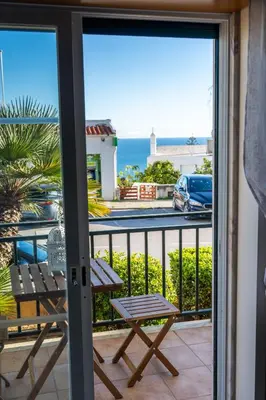 a balcony with a table and a view of the ocean at Old Town Boho Seaview Elegance in Albufeira