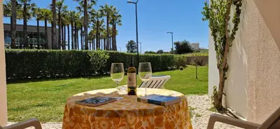 a table with two glasses of wine on it at Sao Rafael Village 2 Bedroom with a Pool in Albufeira