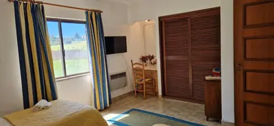 a bedroom with a bed and a window and a desk at Sao Rafael Village 2 Bedroom with a Pool in Albufeira