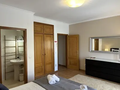 a bedroom with a bed and a sink and a mirror at Moradia B - 200m da Praia da Oura - Leste in Albufeira