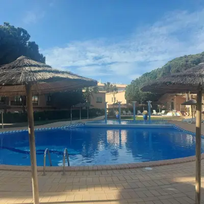 a swimming pool with umbrellas in a resort at Moradia B - 200m da Praia da Oura - Leste in Albufeira
