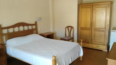 a bedroom with a bed and a wooden cabinet at Residencial Espadinha in Quarteira