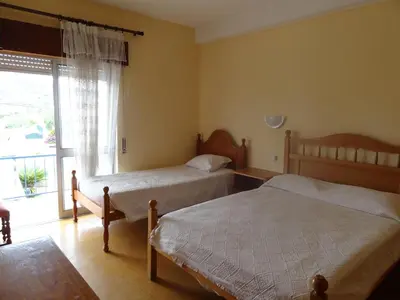 a bedroom with two beds and a large window at Residencial Espadinha in Quarteira