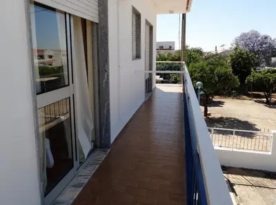 a balcony of a white building with a walkway at Residencial Espadinha in Quarteira