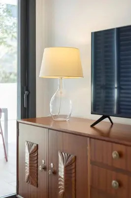 a lamp on top of a dresser with a television at TAC - Alma Apartment in Faro