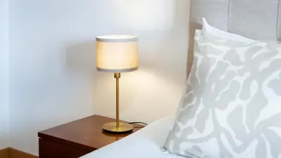 a lamp on a table next to a bed with a pillow at Sunny 3BDR Apt with Pool in Ferreiras by LovelyStay in Albufeira