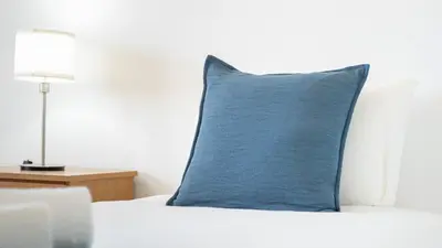 a blue pillow sitting on top of a bed at Sunny 3BDR Apt with Pool in Ferreiras by LovelyStay in Albufeira