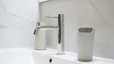 a bathroom with two faucets on a sink at Sunny 3BDR Apt with Pool in Ferreiras by LovelyStay in Albufeira