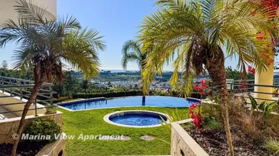 a garden with palm trees and a swimming pool at Albufeira Vista Marina Apt - Old Town in Albufeira