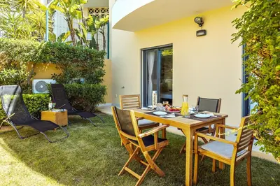 a patio with a wooden table and chairs at Albufeira Vista Marina Apt - Old Town in Albufeira
