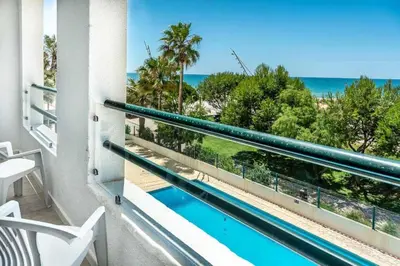 a bedroom with a bed with a dresser and a window at Quarteira First Line Front Beach Pool Flat View in Quarteira