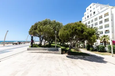 a tree in the middle of a building at Quarteira First Line Front Beach Pool Flat View in Quarteira