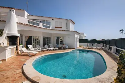 a swimming pool in front of a house at Villa Rebelo in Albufeira