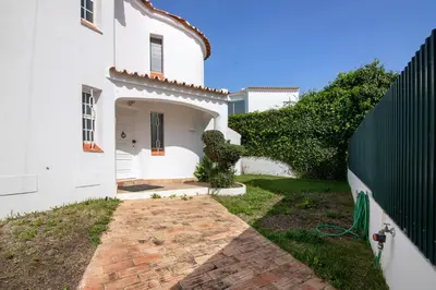 a white house with a gate and a brick walkway at Villa Rebelo in Albufeira