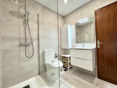 a bathroom with a toilet and a shower and a door at Albufeira Ocean View III by Homing in Albufeira