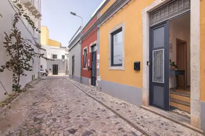 an empty street in an alley with a door at Casa Viola in Faro