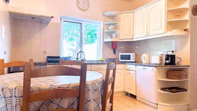 a kitchen with a table and a sink and a microwave at Casa das ficus in Guia