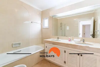 a bathroom with a tub and a sink and a mirror at #293 Clube Albufeira 309 by Home Holidays in Albufeira
