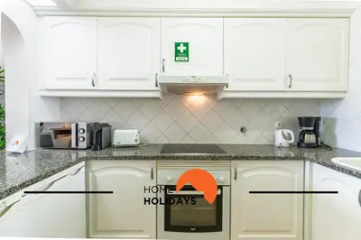 a kitchen with white cabinets and a sign that says happy holidays at #293 Clube Albufeira 309 by Home Holidays in Albufeira