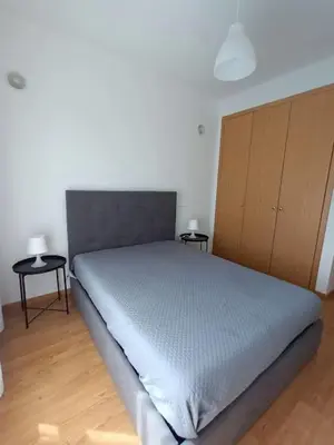 a bedroom with a bed with two tables and a cabinet at T2 Faro in Faro