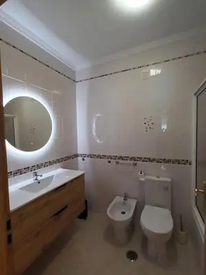 a bathroom with a sink and a toilet and a mirror at T2 Faro in Faro