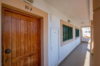 a hallway with a wooden door and a balcony at Azinhais Apartment - Heart of Oura in Albufeira