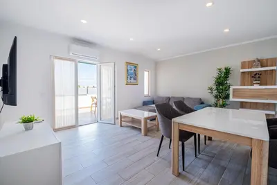 a kitchen and living room with a table and a couch at Azinhais Apartment - Heart of Oura in Albufeira