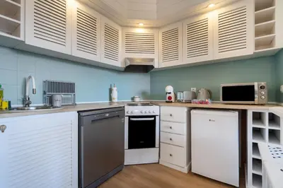 a kitchen with white cabinets and a stove top oven at NEW! Perfect Studio with Swimming Pool in Albufeira