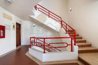 a staircase with red railings in a building at NEW! Perfect Studio with Swimming Pool in Albufeira