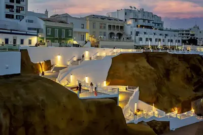 a group of buildings and stairs in a town at night at NEW! Perfect Studio with Swimming Pool in Albufeira