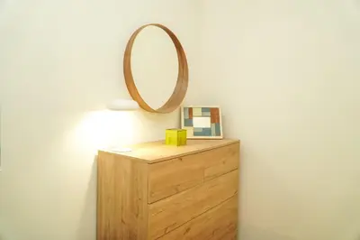 a wooden dresser with a mirror on top of it at Stanchion Apartment in Albufeira