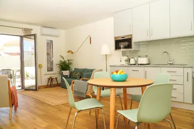 a kitchen and living room with a table and chairs at Stanchion Apartment in Albufeira